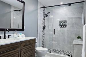 a bathroom with a shower with a toilet and a sink at Paradise Vacation Home in Boynton Beach +27 photos