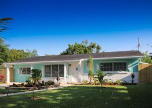 a white and blue house with a yard at Paradise Vacation Home in Boynton Beach