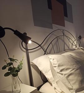 une lampe assise sur une table à côté d'un lit dans l'établissement Casa vacanza Melf, à Terrasini