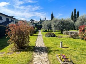 a path through a garden with flowers and trees at Paradise Convent apartment in Casellina +15 photos