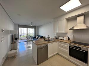 eine Küche mit Spüle und Herd oberen Backofen in der Unterkunft EDIFICIO CORUÑA CALA DE FINESTRAT. Luxury apt. in Benidorm