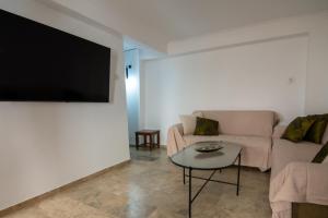 ハニア・タウンにあるCasa Bollani - Old Town Chania Houseのソファと壁掛けテレビのあるリビングルーム