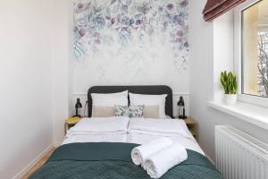 a bedroom with a bed with a floral mural on the wall at Glamour Art Apartment near POLIN musuem WWA12 in Warsaw