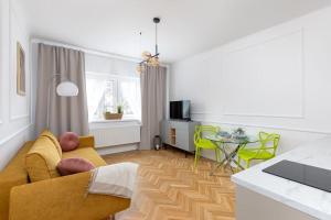 a living room with a yellow couch and a table at Glamour Art Apartment near POLIN musuem WWA12 in Warsaw