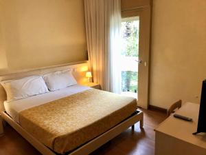 Habitación de hotel con cama y ventana en Hotel B&B Risorta en Abano Terme