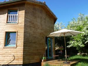 a house with an umbrella and a table at gite les Coulets Naves Les Vans in Les Vans