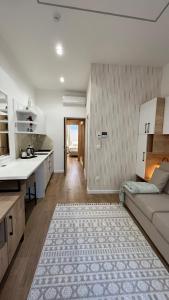 een keuken en een woonkamer met een bank en een tafel bij Sarajevo CODE in Sarajevo