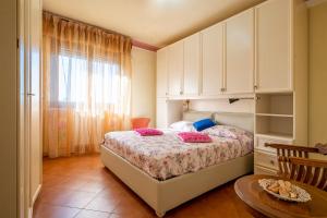 a bedroom with a bed and a table and a window at La Casina di Franco in Piano di Mommio