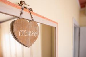 a wooden heart hanging on a door at La Casina di Franco in Piano di Mommio +13 photos