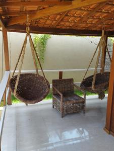 dos cestas colgando de un techo con una silla en Pousada Rangel, en Santo Amaro