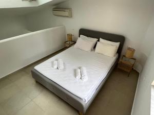 1 dormitorio con 1 cama con 2 toallas en Seafront Loft - Akti Elia, en Nikiti