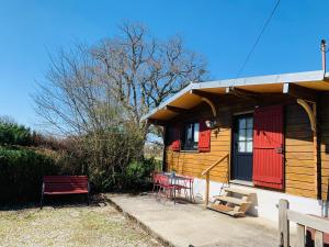 Casa pequeña con puertas rojas, mesa y sillas en Chalet de la Baume en La Châtelaine