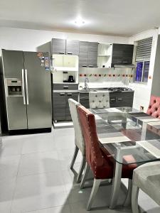 a kitchen with a table and a stainless steel refrigerator at Apartamento Rio Guatapurí in Valledupar