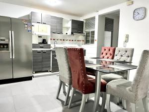 cocina con mesa, sillas y nevera en Apartamento Rio Guatapurí en Valledupar