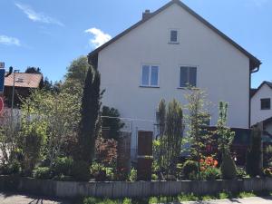 una casa blanca con un jardín delante de ella en Charmante Ferienwohnung en Kaufbeuren