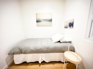 a bed in a white room with a table at HOM l Departamento 3PAX A l A Lastarria in Santiago
