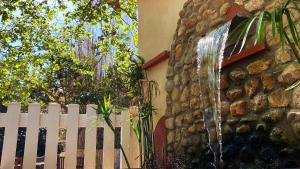 une clôture blanche et une fontaine à eau à côté d'un bâtiment dans l'établissement Domaine du Mas Bazan, à Alénya