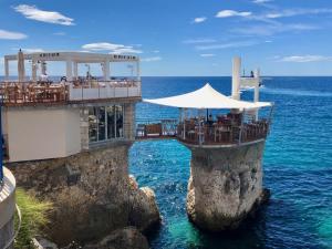 a restaurant on a cliff in the water at Charmant Studio à proximité du Port de Nice in Nice