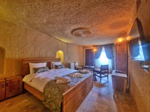ギョレメにあるMuskara Cave Hotelのベッドルーム1室(大型ベッド1台付)