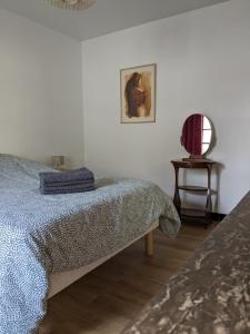 a bedroom with a bed and a table with a chair at Au chalet d'Illiers Combray, grand jardin arboré in Illiers