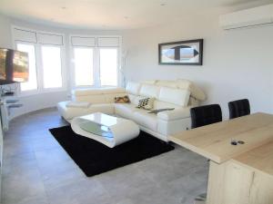 ein Wohnzimmer mit einem weißen Sofa und einem Tisch in der Unterkunft Villa avec piscine et vue panoramique mer in Roses