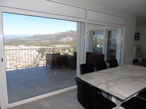 a room with a table and a balcony with a view at Villa avec piscine et vue panoramique mer in Roses