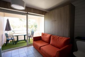 ein Wohnzimmer mit einem roten Sofa und einem Tisch in der Unterkunft Résidence du Parc Hossegor in Hossegor