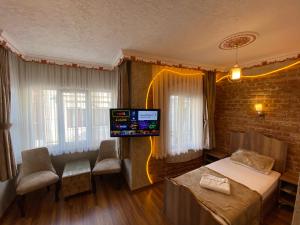 ein Schlafzimmer mit einem Bett und einem TV an der Wand in der Unterkunft GOLDEN ARROW OLD CİTY HOTEL in Istanbul