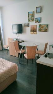 een kamer met een tafel en stoelen en een televisie bij Sunny Beach Studio in Apartcomplex Solmarine in Sunny Beach