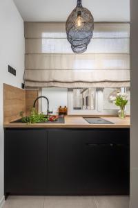 a kitchen with black cabinets and a sink at Apartment Centro Pola in Pula