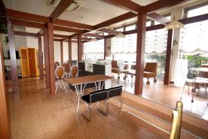 una sala da pranzo con tavoli, sedie e finestre di Hotel Hakusan Hills a Hakusan