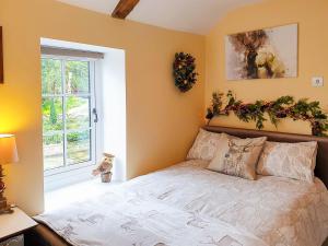 a bedroom with a bed with areath on the wall at Christmas Cottage in Cheddar