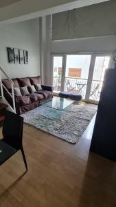 een woonkamer met een bank en een glazen tafel bij Duplex en el Corazón de Recoleta in Buenos Aires