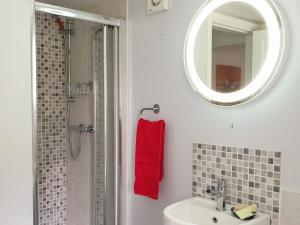 a bathroom with a sink and a mirror and a shower at Christmas Cottage in Cheddar