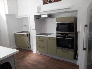 uma cozinha com armários amarelos e um forno com placa de fogão em Gîte "Chez elles" à Arnac-Pompadour em Arnac-Pompadour