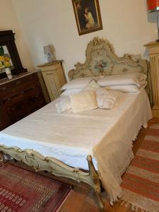 1 dormitorio con 1 cama grande con sábanas y almohadas blancas en Casa Burraia, en Abbadia di Montepulciano