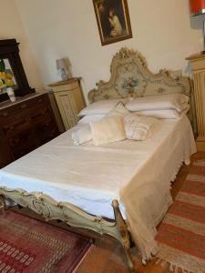 a bedroom with a large bed with white sheets and pillows at Casa Burraia in Abbadia di Montepulciano