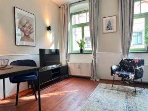 sala de estar con escritorio y silla en Hip & Minimalist - Stadt Apartments am Malerweg, en Pirna