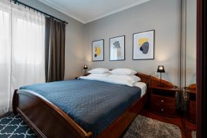 sypialnia z łóżkiem z niebieską kołdrą w obiekcie Apartamenty Tespis - Dębowe Tarasy w mieście Katowice