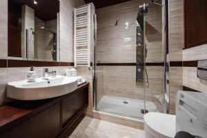 a bathroom with a sink and a shower at Apartamenty Tespis - Dębowe Tarasy in Katowice