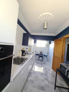 a kitchen with a stove and a table in it at Dar Babou in Rabat