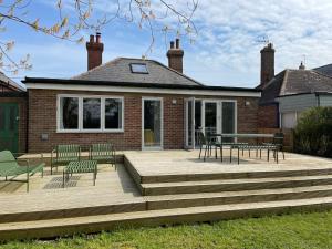 a deck with chairs and a table on a house at Seaside Retreat in Rye Harbour