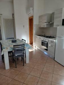 a kitchen with a table with chairs and a refrigerator at Casa Santoreggia Olbia, Porto Istana, Murta Maria in Murta Maria +9 photos