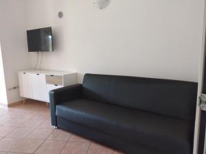 a black couch in a living room with a tv at Casa Santoreggia Olbia, Porto Istana, Murta Maria in Murta Maria