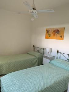 a bedroom with two beds and a ceiling fan at Apart Ocampo Catamarca in San Fernando del Valle de Catamarca