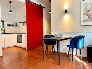 ピルナにあるHip & Minimalist - Stadt Apartments am Malerwegの赤いドア付きのキッチン(テーブル、椅子付)