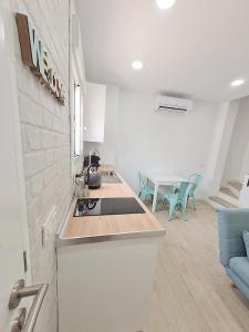 a kitchen with a stove and a table in a room at Gemini Conil in Conil de la Frontera