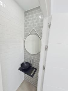 a bathroom with a sink and a mirror at Gemini Conil in Conil de la Frontera