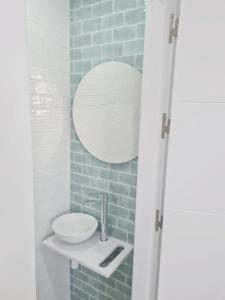 a bathroom with a sink and a mirror at Gemini Conil in Conil de la Frontera