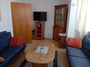 a living room with a coffee table and a tv at Ferienwohnung Petersen I in Büdelsdorf
